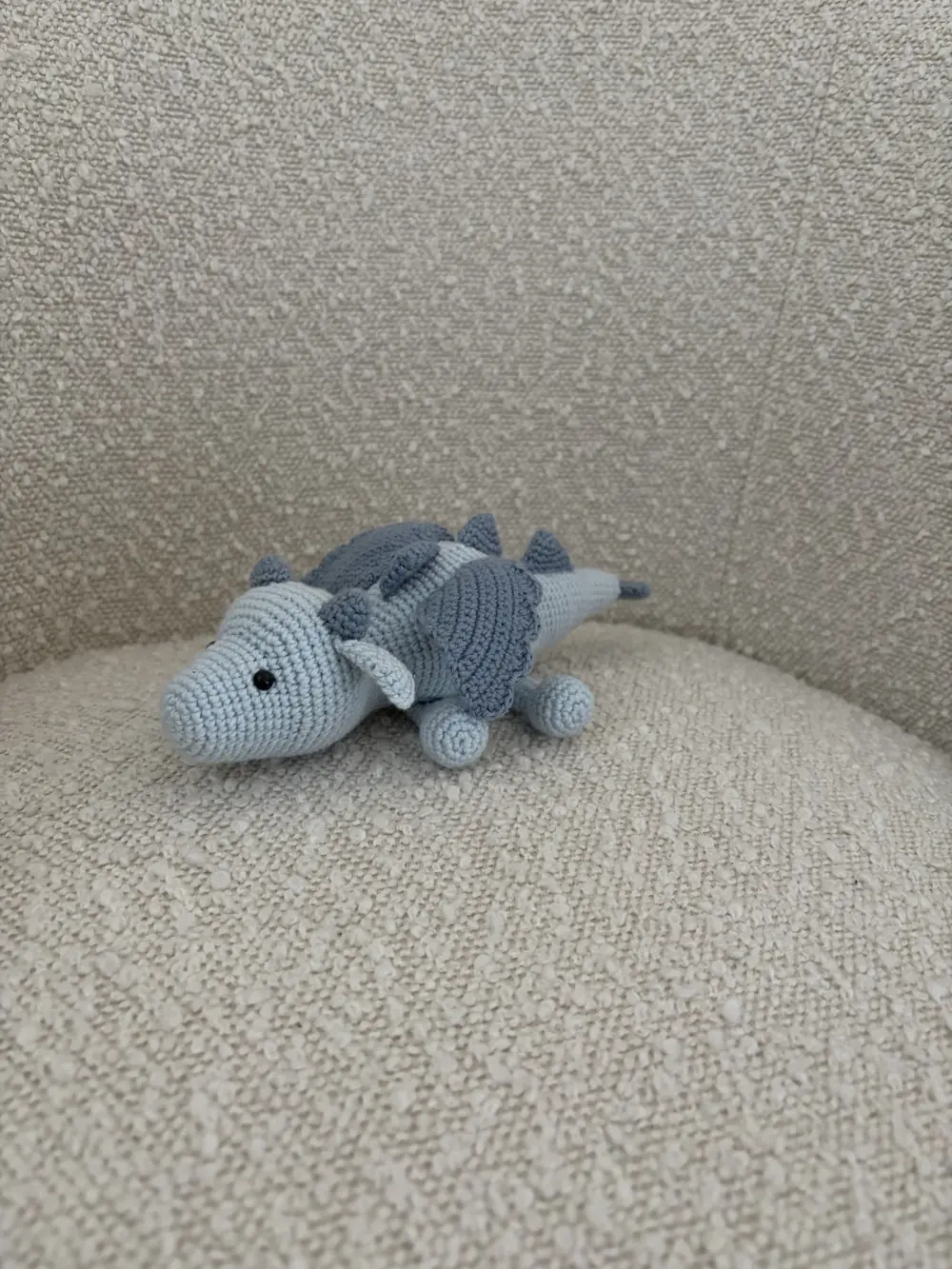 A small crocheted blue dragon toy