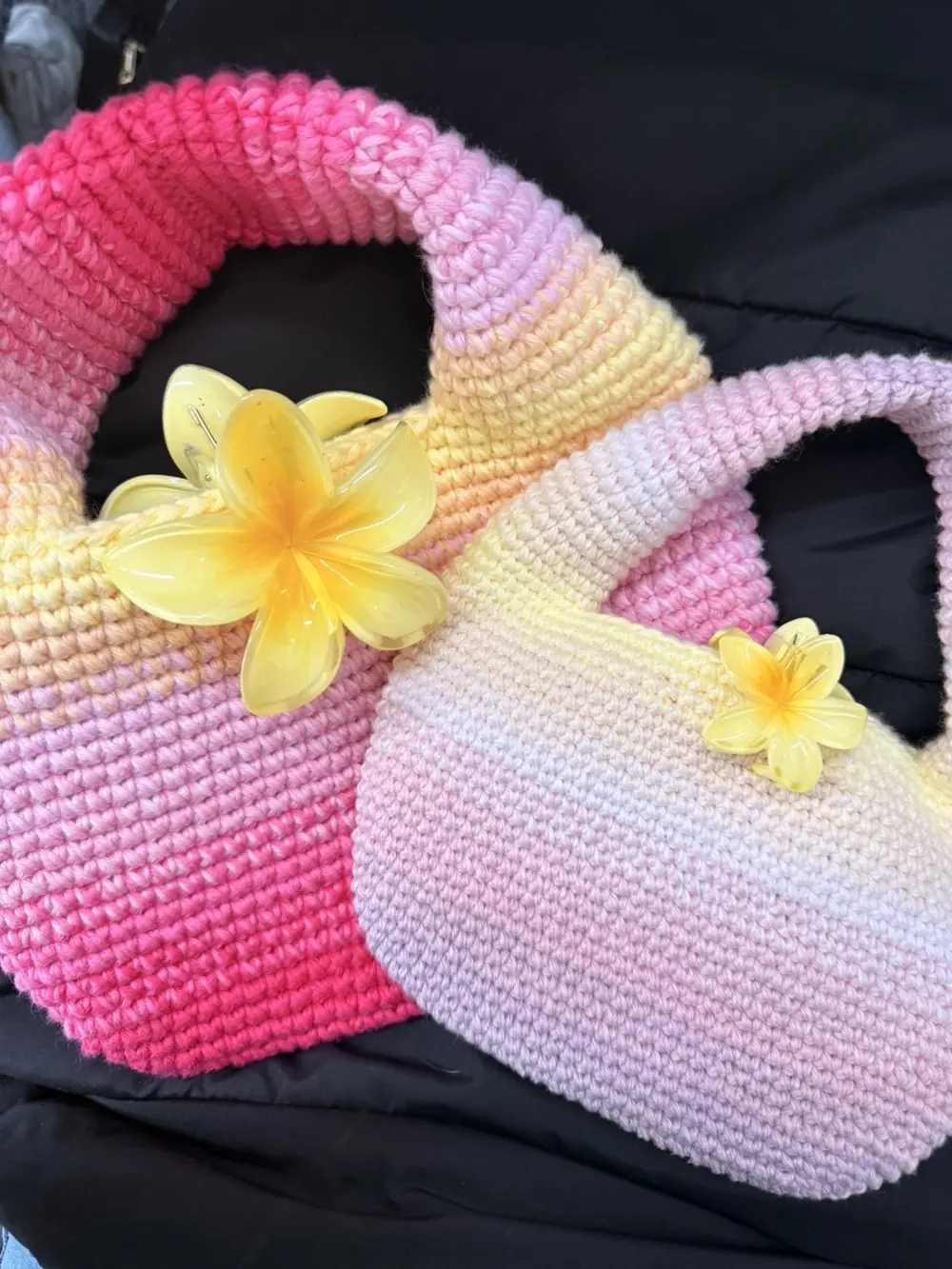 Two crocheted bags fading from pink to lemon